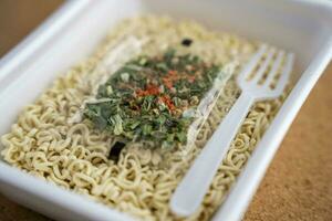 Chinese noodles with a bag of dried vegetables. close-up. Instant noodles photo