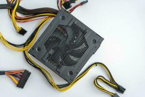 a powerful new computer power supply with connection cables on a white background photo
