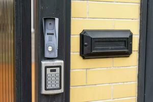 intercom panel with a video camera on the brick fence of private house photo