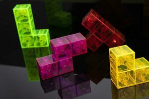 colored tetris figures on glossy black glass, space for copying photo