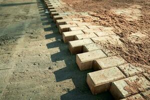 not fully laid paving slabs on the site prepared for laying photo