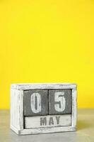 May 5, Wooden desktop calendar yellow background.Spring month depicted on cubes.Place for your ideas. photo