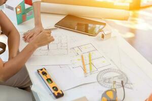 Engineers and designers are discussing the layout of the house and the construction schedule to be completed on schedule. House construction ideas with a team of professional engineers and designers. photo