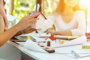 Engineers and designers are discussing the layout of the house and the construction schedule to be completed on schedule. House construction ideas with a team of professional engineers and designers. photo