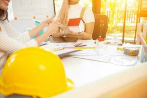 Engineers and designers are discussing the layout of the house and the construction schedule to be completed on schedule. House construction ideas with a team of professional engineers and designers. photo
