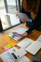 Businesswoman hands working on stacks of paper documents to search and review documents piled on table before sending them to board of directors to use  correct documents in meeting with Businessman photo