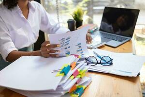Businesswoman hands working on stacks of paper documents to search and review documents piled on table before sending them to board of directors to use  correct documents in meeting with Businessman photo