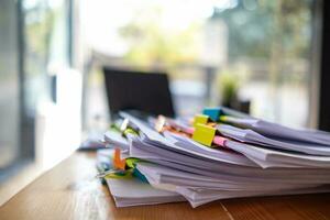 Businesswoman hands working on stacks of paper documents to search and review documents piled on table before sending them to board of directors to use  correct documents in meeting with Businessman photo