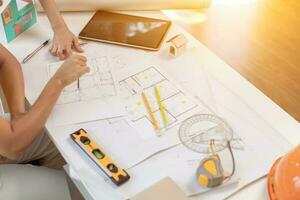 Engineers and designers are discussing the layout of the house and the construction schedule to be completed on schedule. House construction ideas with a team of professional engineers and designers. photo