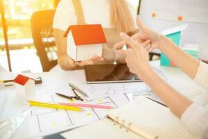 Engineers and designers are discussing the layout of the house and the construction schedule to be completed on schedule. House construction ideas with a team of professional engineers and designers. photo