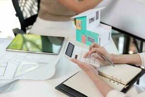 Engineers and designers are discussing the layout of the house and the construction schedule to be completed on schedule. House construction ideas with a team of professional engineers and designers. photo