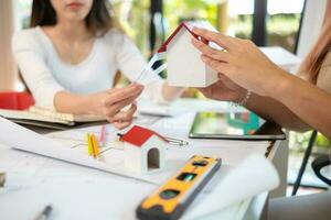 Engineers and designers are discussing the layout of the house and the construction schedule to be completed on schedule. House construction ideas with a team of professional engineers and designers. photo