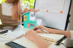 Engineers and designers are discussing the layout of the house and the construction schedule to be completed on schedule. House construction ideas with a team of professional engineers and designers. photo