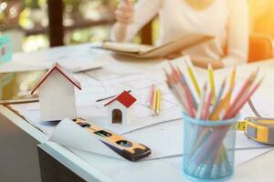 Engineers and designers are discussing the layout of the house and the construction schedule to be completed on schedule. House construction ideas with a team of professional engineers and designers. photo