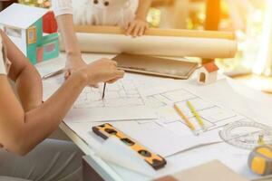 Engineers and designers are discussing the layout of the house and the construction schedule to be completed on schedule. House construction ideas with a team of professional engineers and designers. photo