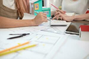 Engineers and designers are discussing the layout of the house and the construction schedule to be completed on schedule. House construction ideas with a team of professional engineers and designers. photo