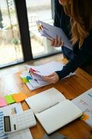 Businesswoman hands working on stacks of paper documents to search and review documents piled on table before sending them to board of directors to use  correct documents in meeting with Businessman photo