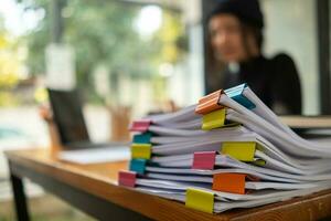 Businesswoman hands working on stacks of paper documents to search and review documents piled on table before sending them to board of directors to use  correct documents in meeting with Businessman photo