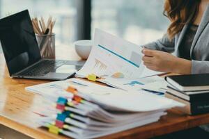 Businesswoman hands working on stacks of paper documents to search and review documents piled on table before sending them to board of directors to use  correct documents in meeting with Businessman photo