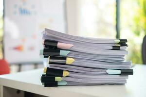 Businesswoman hands working on stacks of paper documents to search and review documents piled on table before sending them to board of directors to use  correct documents in meeting with Businessman photo