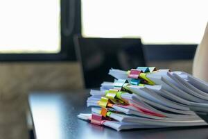 mujer de negocios manos trabajando en pilas de papel documentos a buscar y revisión documentos apilado en mesa antes de enviando ellos a tablero de directores a utilizar correcto documentos en reunión con empresario foto