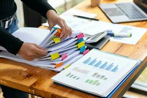 Businesswoman hands working on stacks of paper documents to search and review documents piled on table before sending them to board of directors to use  correct documents in meeting with Businessman photo