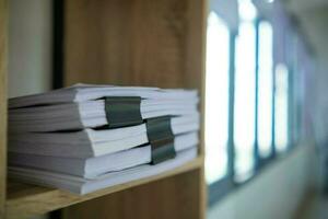 Businesswoman hands working on stacks of paper documents to search and review documents piled on table before sending them to board of directors to use  correct documents in meeting with Businessman photo