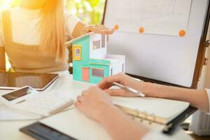 Engineers and designers are discussing the layout of the house and the construction schedule to be completed on schedule. House construction ideas with a team of professional engineers and designers. photo