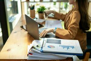 Businesswoman hands working on stacks of paper documents to search and review documents piled on table before sending them to board of directors to use  correct documents in meeting with Businessman photo