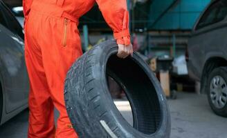 A car mechanic inspects the condition of a car tire before placing it on a vehicle. photo