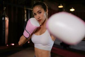 Portrait of woman learning Muay Thai to build up the strength of the body and use it for self-defense. photo