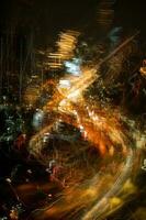 Abstract image of busy lights at night in a city with moving cars on the road. photo