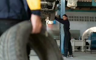 A car mechanic inspects the condition of a car tire before placing it on a vehicle. photo