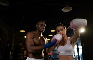 Instructor in a fitness facility Training female boxers to use the martial art of Muay Thai to be used as a defensive weapon photo