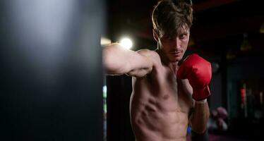 Portrait of boxers must practice their kicking and punching skills with punching bag. To build strength and power of kicking and punching. photo