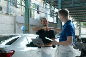 Both of technician inspects the condition of the car that has been polished and coated with glass. photo