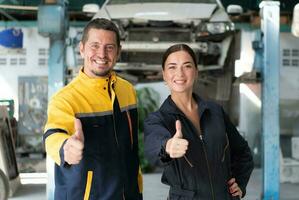 Portrait of engineer and auto mechanic with working on engine repairs in car garages photo