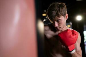 Portrait of boxers must practice their kicking and punching skills with punching bag. To build strength and power of kicking and punching. photo