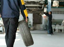 A car mechanic inspects the condition of a car tire before placing it on a vehicle. photo