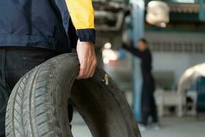 A car mechanic inspects the condition of a car tire before placing it on a vehicle. photo