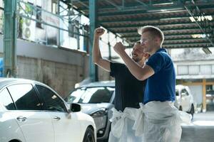 Both of technician inspects the condition of the car that has been polished and coated with glass. photo