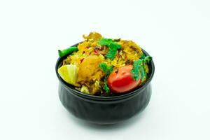 Isolated delicious spicy chicken biryani in black bowl on white background photo