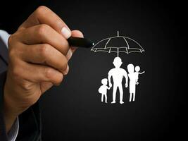 hombre señalando mediante el bolígrafo en el familia icono debajo el paraguas, negocio, bancario y seguro Arte foto