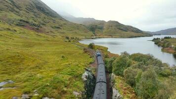 Steam Train in Scotland Passing By a Loch on the Famous Route video