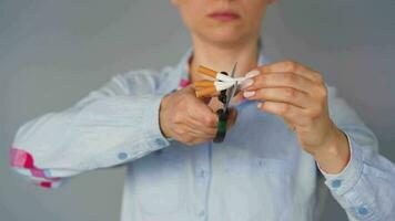 Quit smoking concept, woman cuts cigarettes with scissors. video