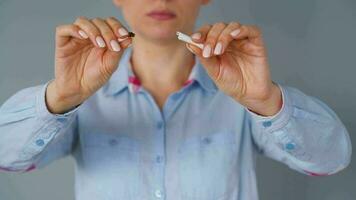 Quit smoking concept, woman cuts cigarettes with scissors. video