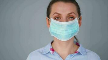 pandemia protezione di il covid-19 coronavirus. caucasico donna nel un' medico viso maschera. virus protezione. video