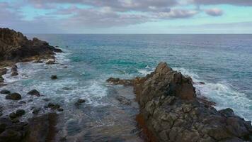 volante al di sopra di il roccioso costa di tenerife e il atlantico oceano, canarino isole, Spagna. aereo fuco metraggio di oceano onde raggiungendo riva video