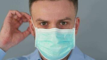 pandemisch bescherming van de covid-19 coronavirus. gebaard Kaukasisch Mens zet Aan een beschermend medisch masker. virus bescherming. video