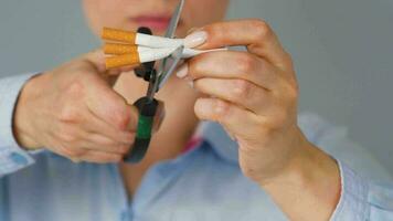 Quit smoking concept, woman cuts cigarettes with scissors. video